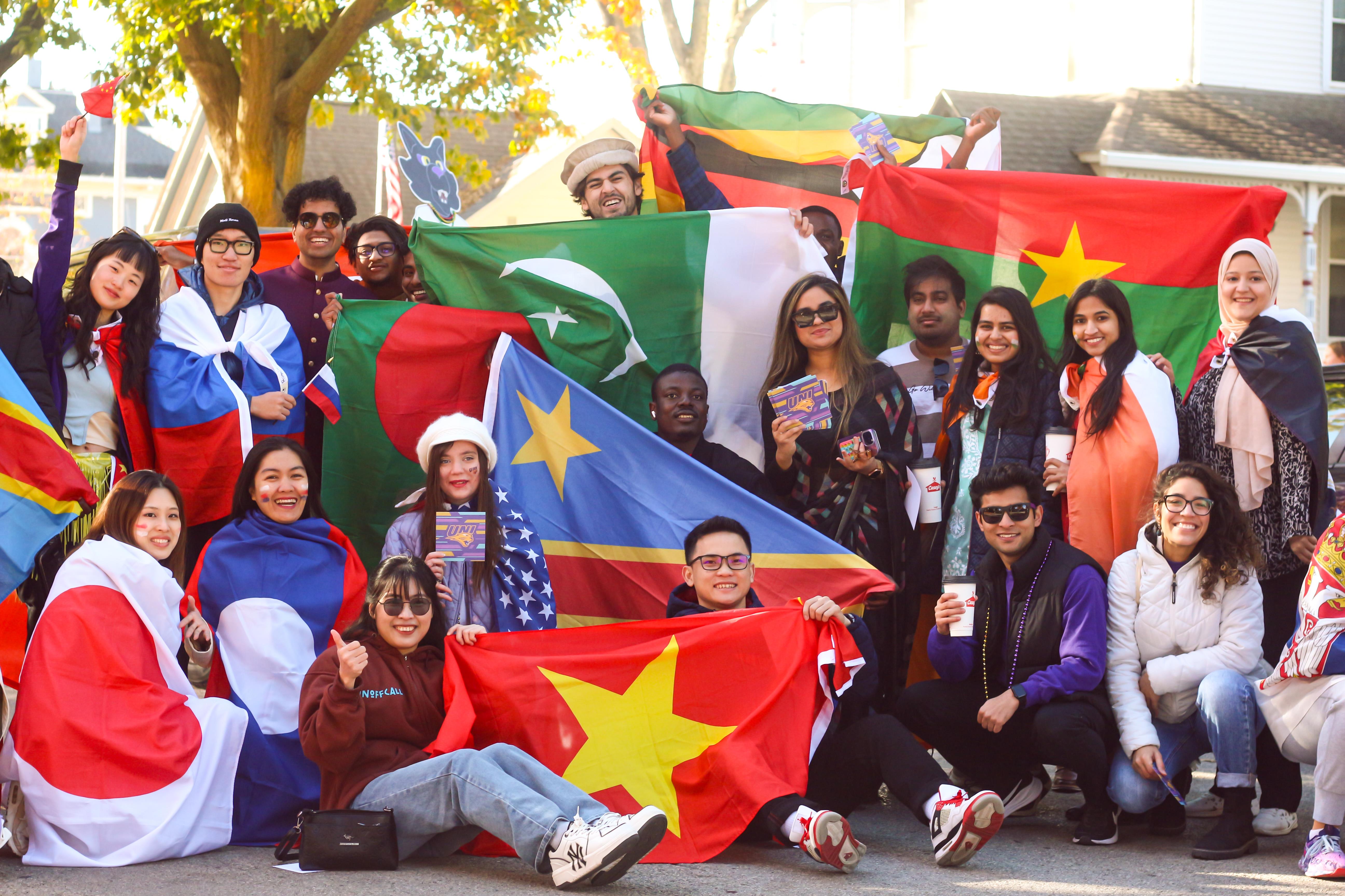 Group of students holding up their countries flags. 