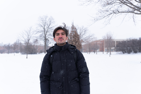 Student Abdul Aziz stands in fresh snowfall on UNI's campus.