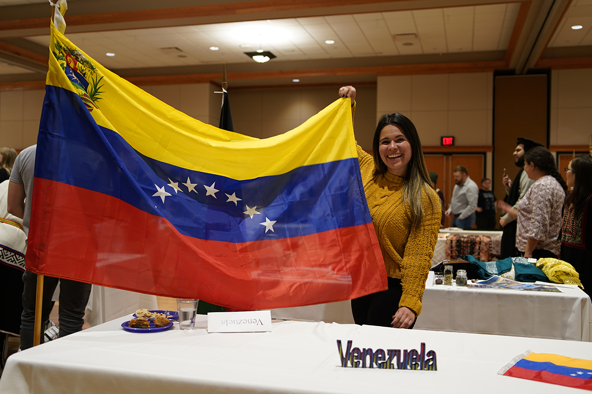 Female international student holding Venezuelan flag.