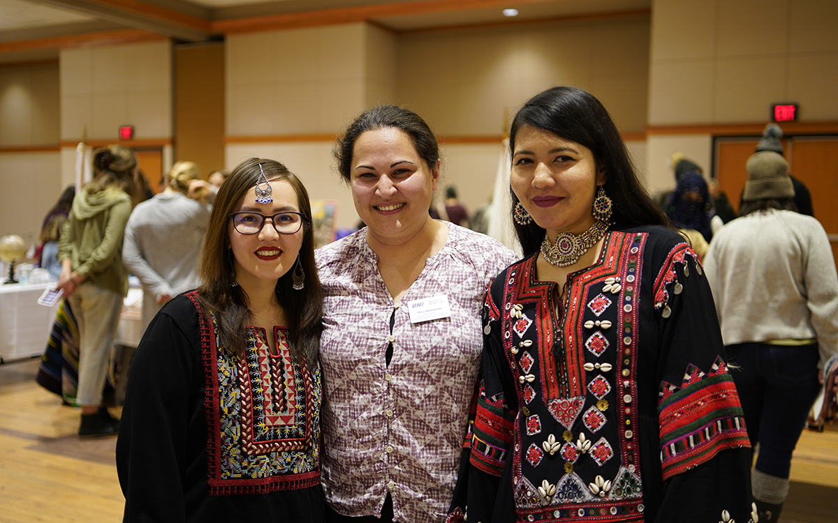 Three female international students arm-in-arm at IEW