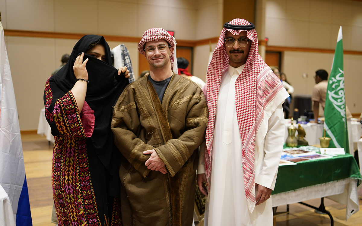 Two male and one female international student dressed in traditional middle eastern garb